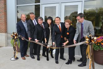 A group of people including couple Lynn Chen-Zang and Charles Zhang cut the ribbon on the Zhang Legacy Collections Center at WMU.