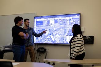 Three students around a map. 