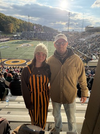A father and daughter at a football game.