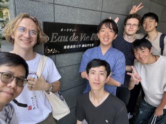 A group photo of students by a building.