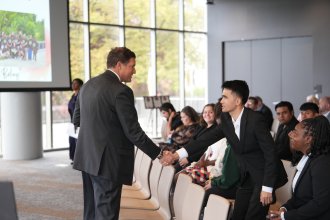 WMU President Russ Kavalhuna and Mehran Najafi shake hands.