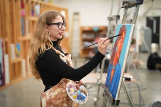 Hope Donovan paints on a canvas.