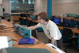 Noah Braasch interacts with computer equipment.