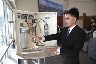 Mehran Najafi displays a water-cleaning device.