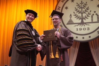 President Russ Kavalhuna shakes A.J. Tate's hand.