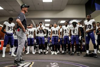 John Harbaugh talks to the Baltimore Ravens team in their lockerroom.