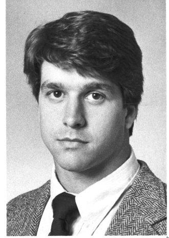 A black and white headshot of a young John Harbaugh.
