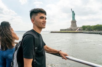 Mehran Najafi rides a boat near the Statue of Liberty.