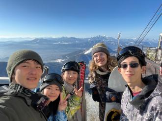 A group photo of people in outdoor gear at the top of a mountain.