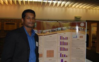 Maran Subramain with a poster representing findings from Chinese language research he has conducted for the Confucius Institute at WMU