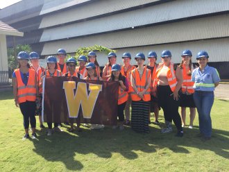 A group of WMU students posing abroad with a WMU banner.
