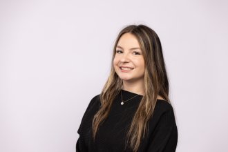 Headshot of Madsion Black in a black blouse on a white background.