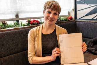 Anna Lane holding a braille menu at a restaurant
