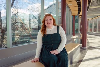 Cybersecurity student Erika Ekblaw sitting in Floyd Hall.