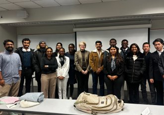 International student from India, Trivedi, stands for photo with WMU students.