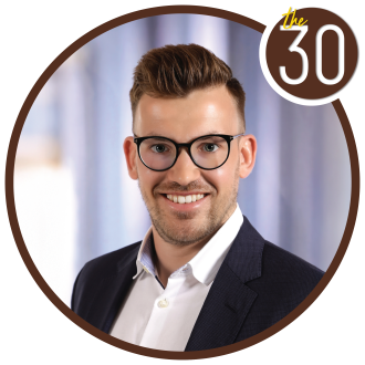 Lenhard Haupt in a suit with a window behind him