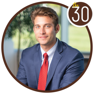 Jonah Shafer, B.B.A.’18 in a suit in front of a course