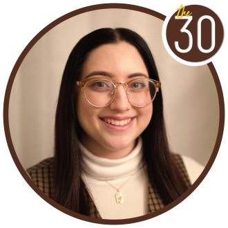Elizabeth Volante, B.B.A.’21 standing in front of a beige backdrop