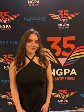 Student standing in front of banner at the NGPA expo.