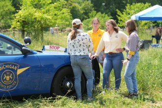 Dr. Ashlyn Kuersten talks with students in the field at a crime scene.