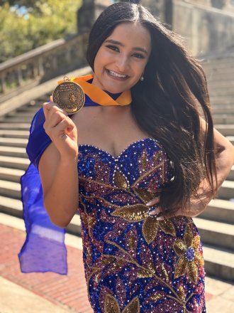 Maya Narayan holds up her Medallion Scholars medal.