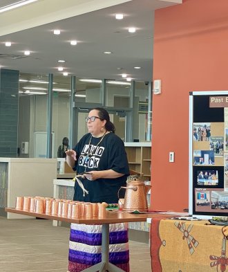 Shannon Martin stands at a table filled with pottery.