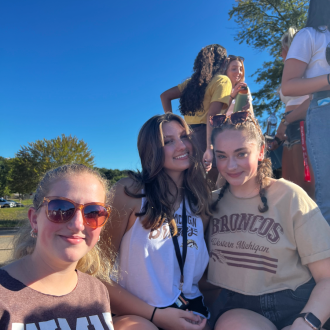 Students sitting in bed of truck at tailgate.