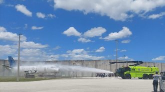 Sharmain Moulton hosting an Aviation Career Exploration Camp - picture of an ARF Firetruck demonstration as it sprays an aircraft with water 