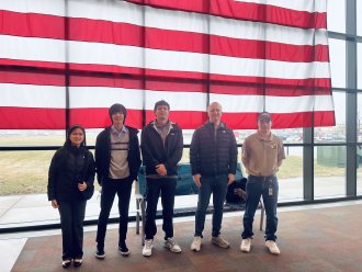 Students in front of american flag.