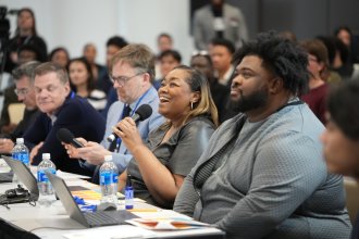 Judges sitting at a table ask a question to a finalist in the Cultivate 269 pitch competition.