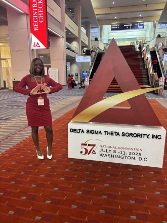 A'maree Waddell stands next to a sign for her sorority.