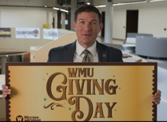 WMU President holding WMU Giving Day sign