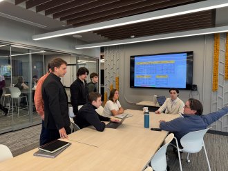 Dr. Derrick McIver meets with Grace Olds and fellow students
