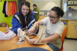 Students saw an antler for an art project.