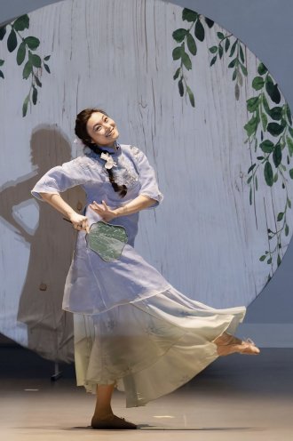 Woman performs Asian cultural dance on stage at Spring Gala.