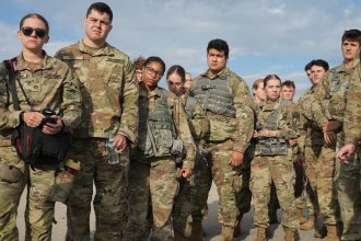 A group of ROTC cadets stands together at training.