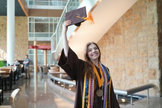 Molly Cochran tosses her graduation cap into the air.