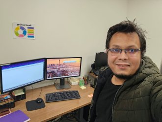 An international student sits at a computer.