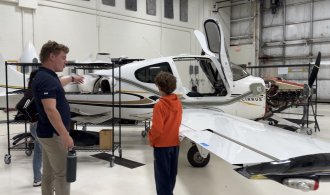 Evan Simpson points out features on an airplane to Vail Fear.