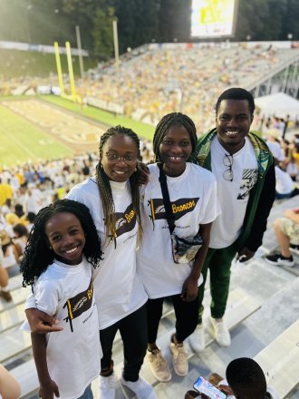 An international student and her friends pose at the stadium during a game at WMU.