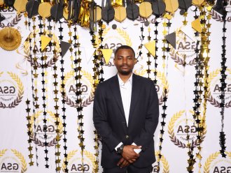 An international student poses on campus at a party.
