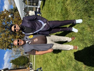 An international student celebrating after being named Homecoming King. He poses with the WMU president.