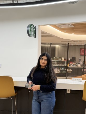 An international student poses near Starbucks in the Student Center.