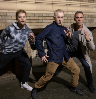 Henry Koperski, Alan Cumming and Ari Shapiro in fighting stances.