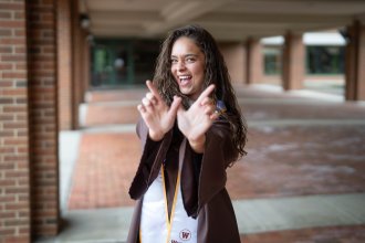 Jadazay Ledbetter celebrates in her graduation regalia.