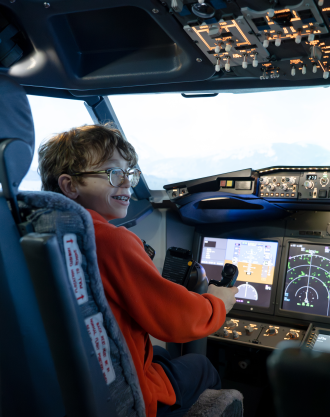 Vail Fear sits in the cockpit of a flight simulator.