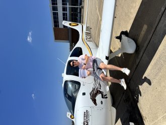 An international aviation student poses by a plane.