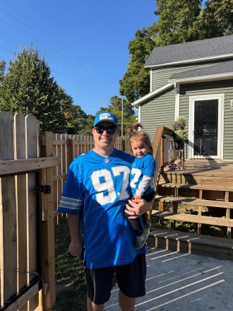 WMU Aviation Management Alunmni AJ Nye in his Lions jersey and his daughter