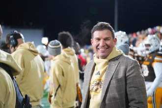 President Kavalhuna stands on the football field.