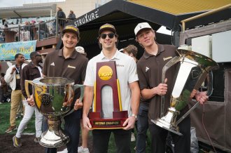 WMU hockey players hold their trophies.